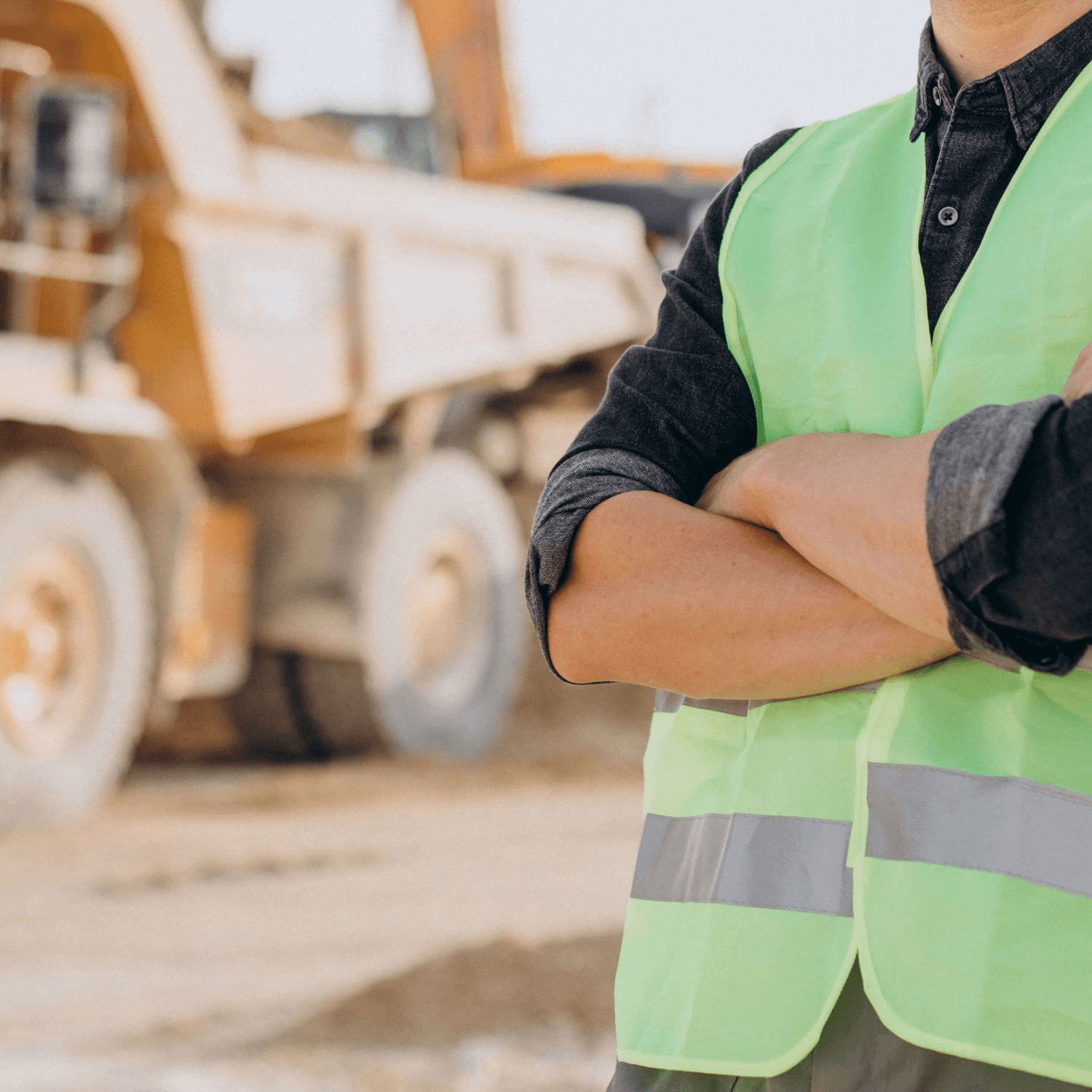 Homem branco de roupa de sinalização de construção em uma obra com um caminhão de obras ao fundo